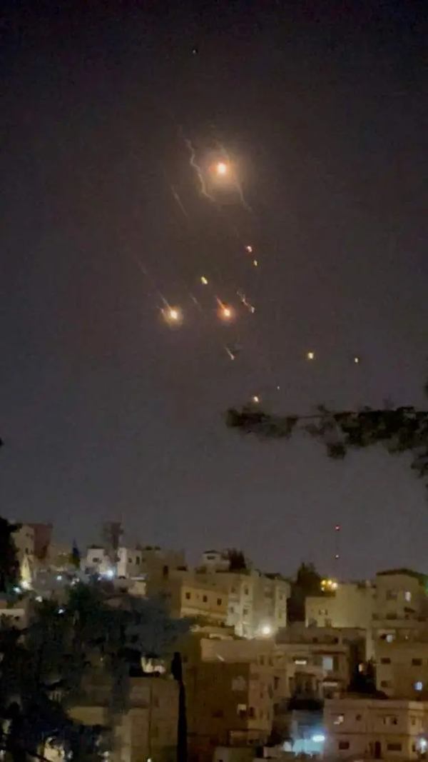 Reuters Підпис до фото, Частина повітряних засобів, випущених Іраном по Ізраїлю, збили над Йорданією. На фото - уламки падають над столицею Йорданії, Амманом