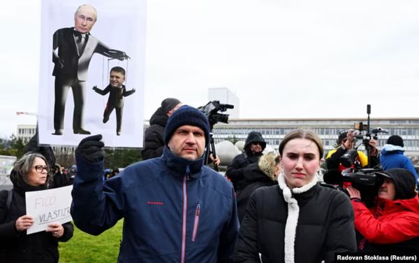 Плакат із зображенням керівника РФ Володимира Путіна і прем&rsquo;єр-міністра Словаччини Роберта Фіцо (праворуч) на мітингу протесту в Братиславі, 23 грудня 2024 року